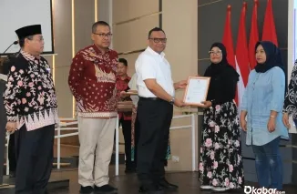 Kepala Kantor Wilayah Kementerian Agama (Kanwil Kemenag Sumbar) Mahyudin bersama dengan Wakil Kepala Badan (Wakaban) BPJPH, Afriansyah Noor, memberikan piagam. (Ist)