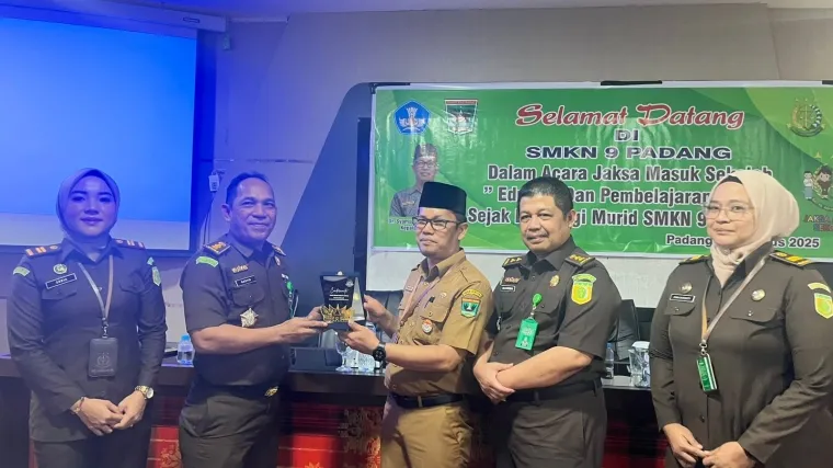 Kepala Seksi Kasi Penerangan Hukum (Kasi Penkum) M.Rasyid, menerima plakat dari dari SMK Negeri 9 Padang. (Ist)