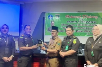 Kepala Seksi Kasi Penerangan Hukum (Kasi Penkum) M.Rasyid, menerima plakat dari dari SMK Negeri 9 Padang. (Ist)