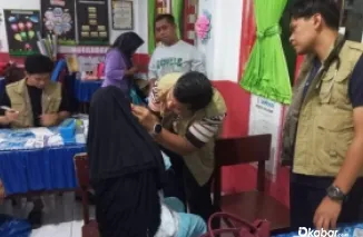 Tim dari Semen Padang Hospital tengah memeriksa kesehatan korban banjir bandang.