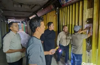 Kepala UPTD Pasar Raya Dinas Perdagangan Kota Padang Muhammad Faisal bersama jajaran saat melakukan penertiban dan penyegelan petak toko penunggak retribusi di kawasan Pasar Raya Barat, Senin (27/7/2026) malam. (Foto: Ist)